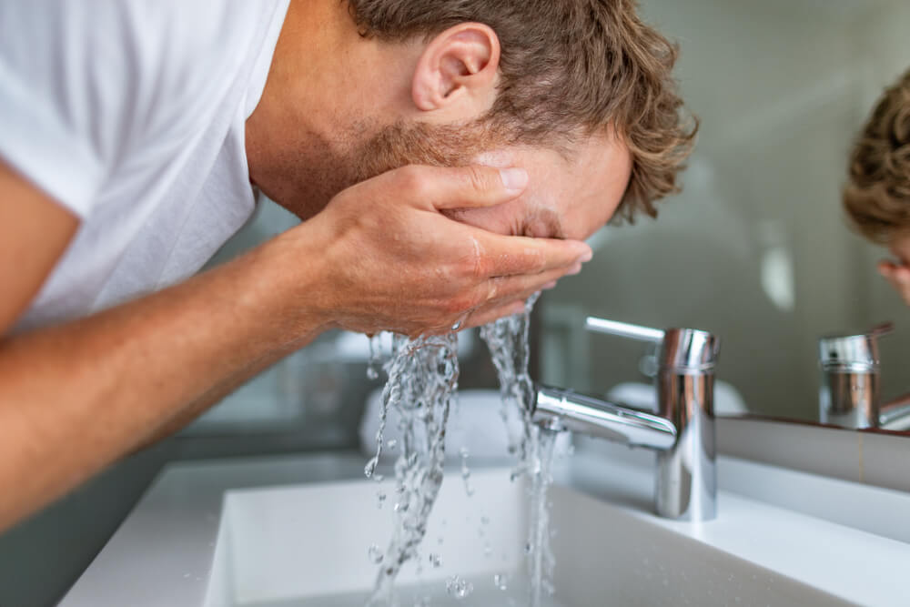 man washing face