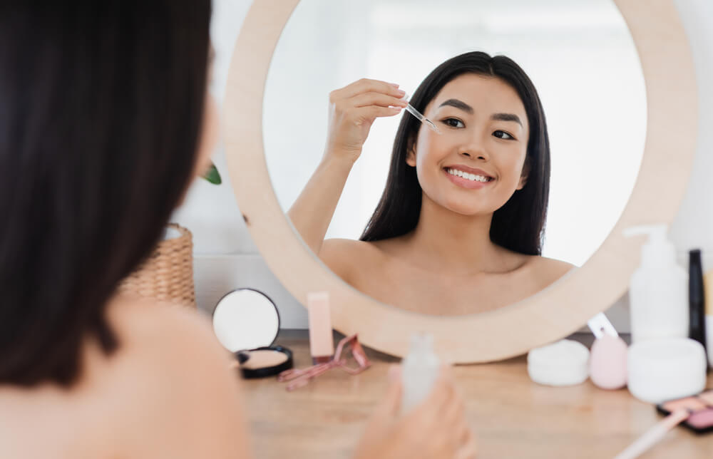 Woman applying eye serum